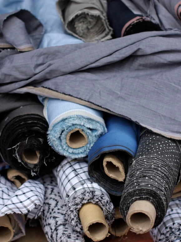 Rolls of blue, grey, black, and patterned fabric